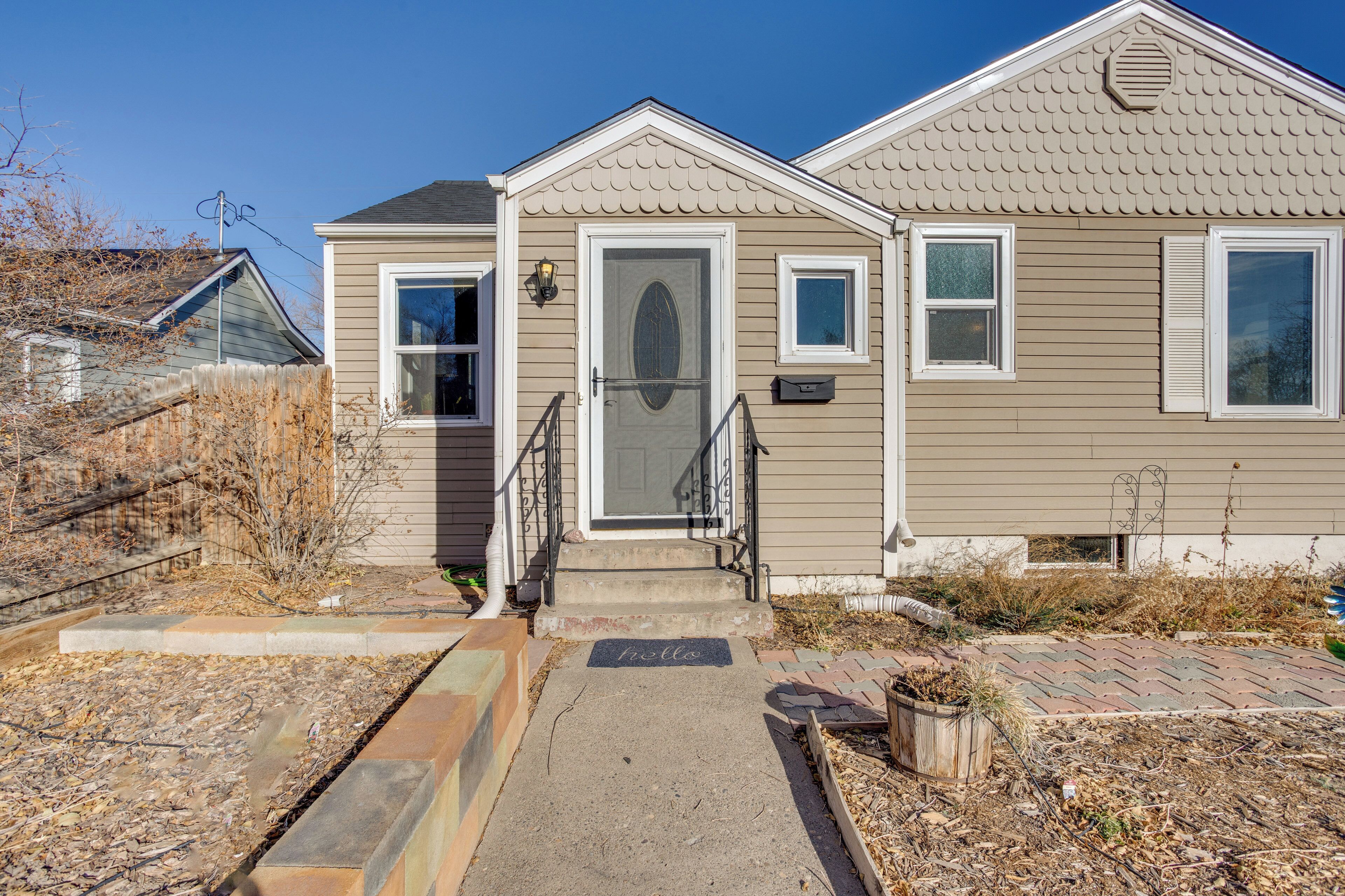 A residential house with a front porch, a mailbox, and a 'hello' mat.
