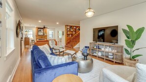 Un salon spacieux avec un canapé bleu, une table basse en bois et une bibliothèque.