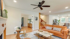 Un salon spacieux doté d’un plancher en bois, d’un canapé blanc, d’une table basse et d’un ventilateur de plafond.