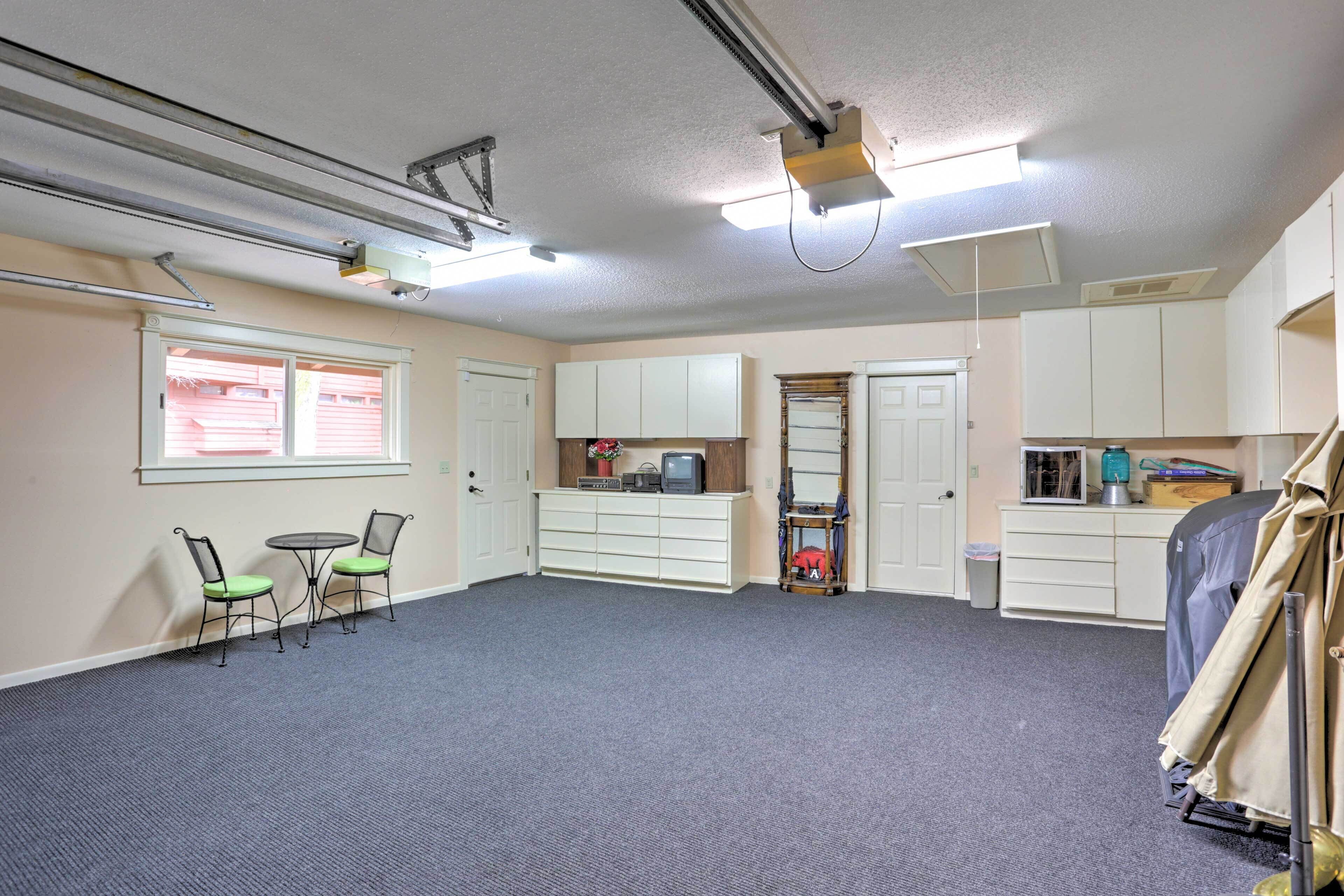 A spacious room with a carpeted floor, a small table with chairs, a television, and a wardrobe.