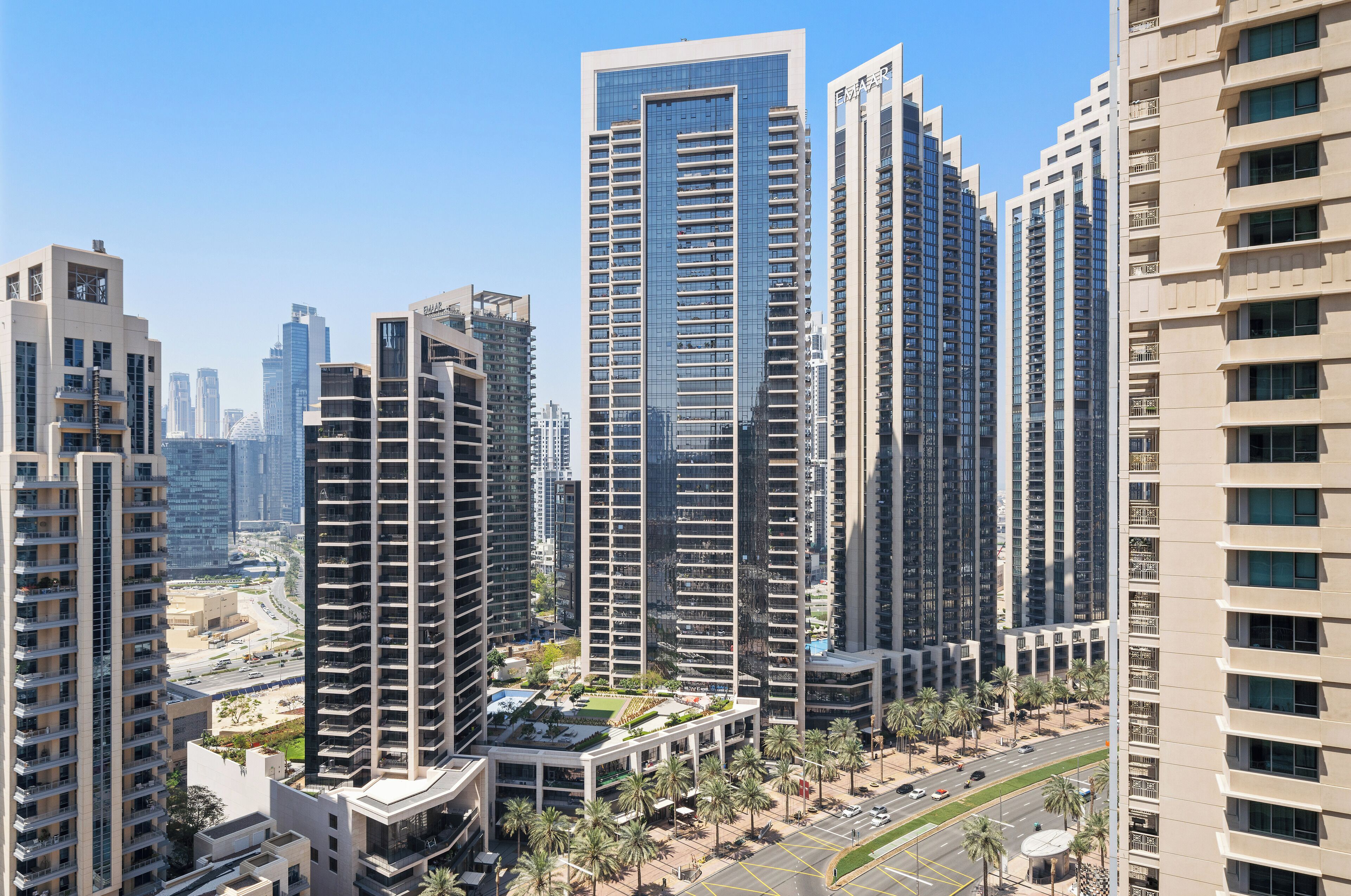 A high-rise residential building with multiple balconies, a rooftop garden, and a modern architectural design.