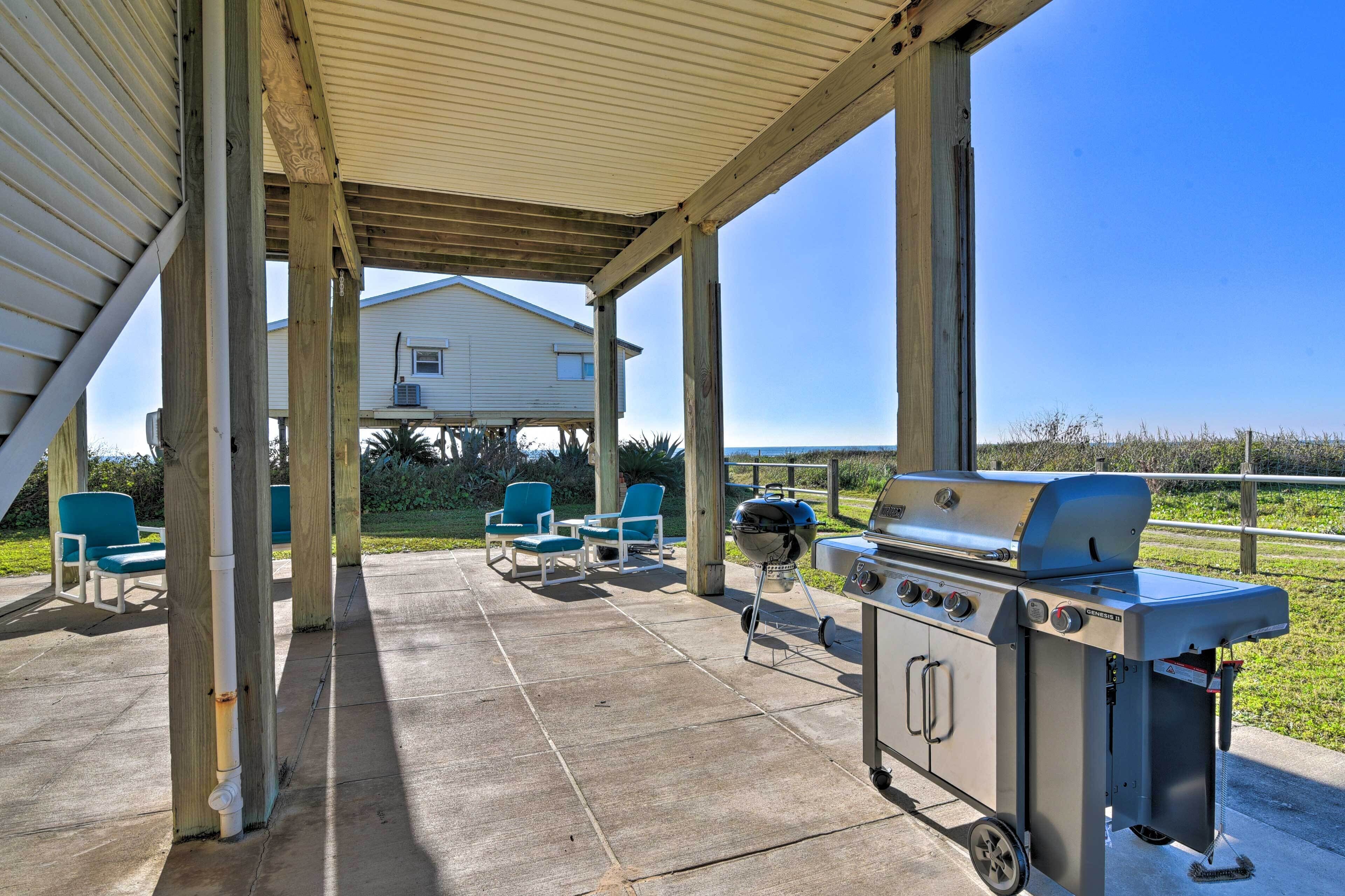 Une terrasse extérieure dotée d’un espace couvert, d’un barbecue et de chaises bleues.