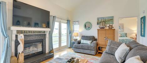 A living room with a fireplace, a sofa, a coffee table, and a television.