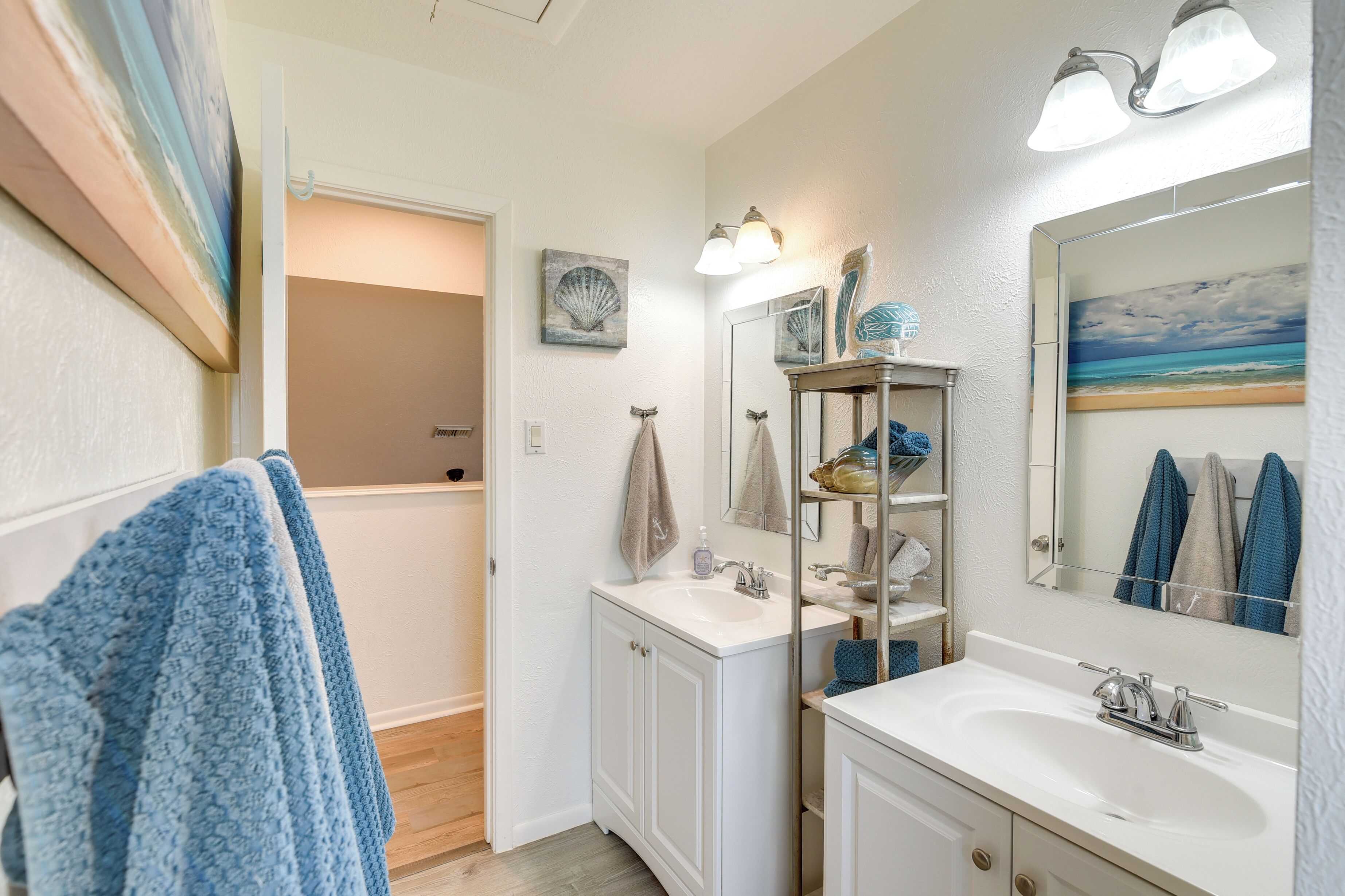 A bathroom with a white vanity, a large mirror, and a shower area.