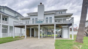 A two-story house with a covered porch, a chimney, and a staircase leading to the upper level. - Pet-friendly Condo w/ Seasonal Pool in Galveston! (Galveston)