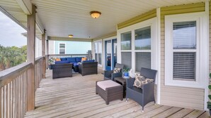 A covered porch with wicker furniture and a view of a house. - Furnished Patio & Deck: Galveston Escape! (Galveston)