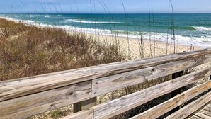 A wooden boardwalk leading to a beach with waves crashing onto the shore. - Gulf Shores Retreat w/ Private Beach Access! (Gulf Shores)