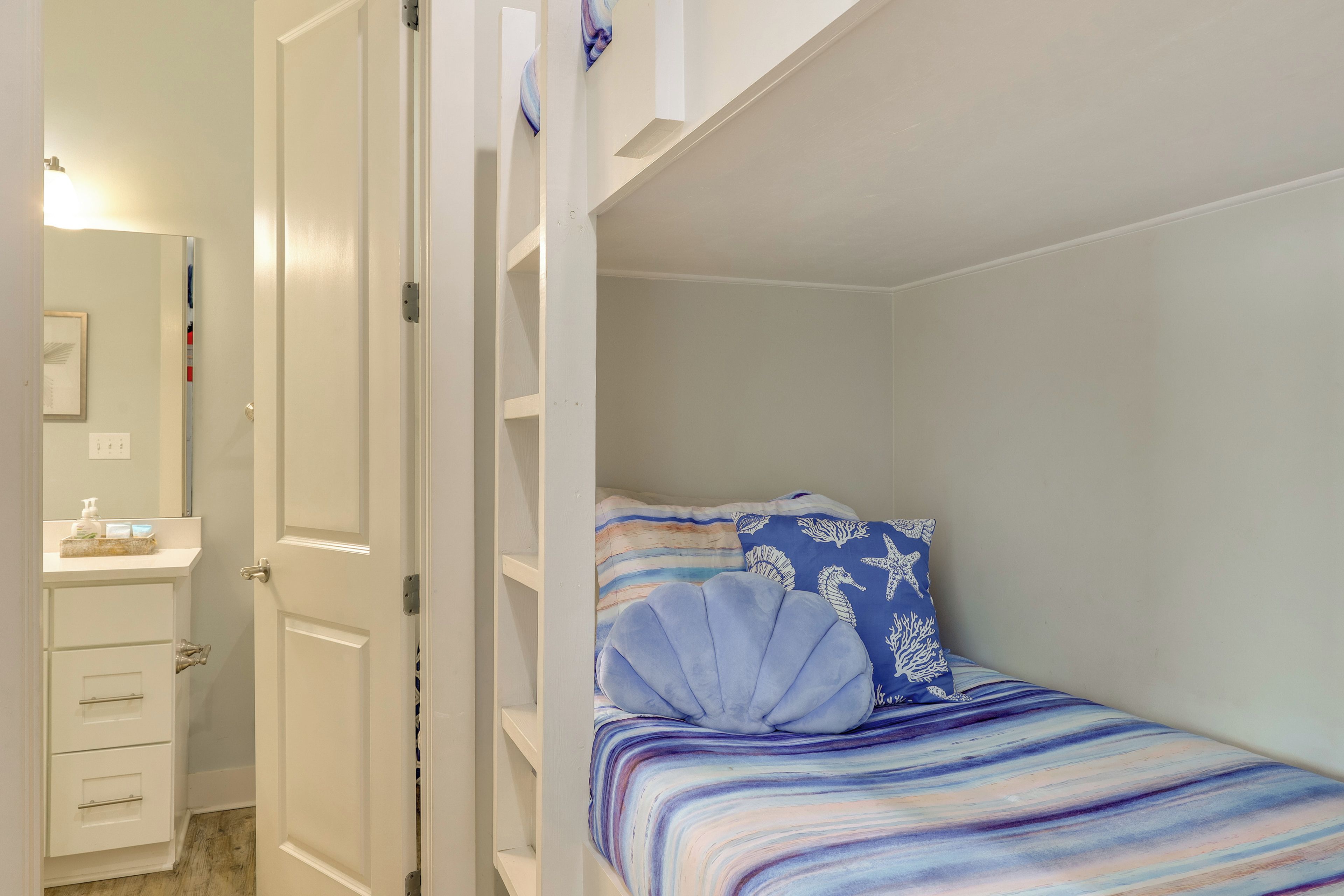 A bedroom with a bed, a nightstand, and a mirror.
