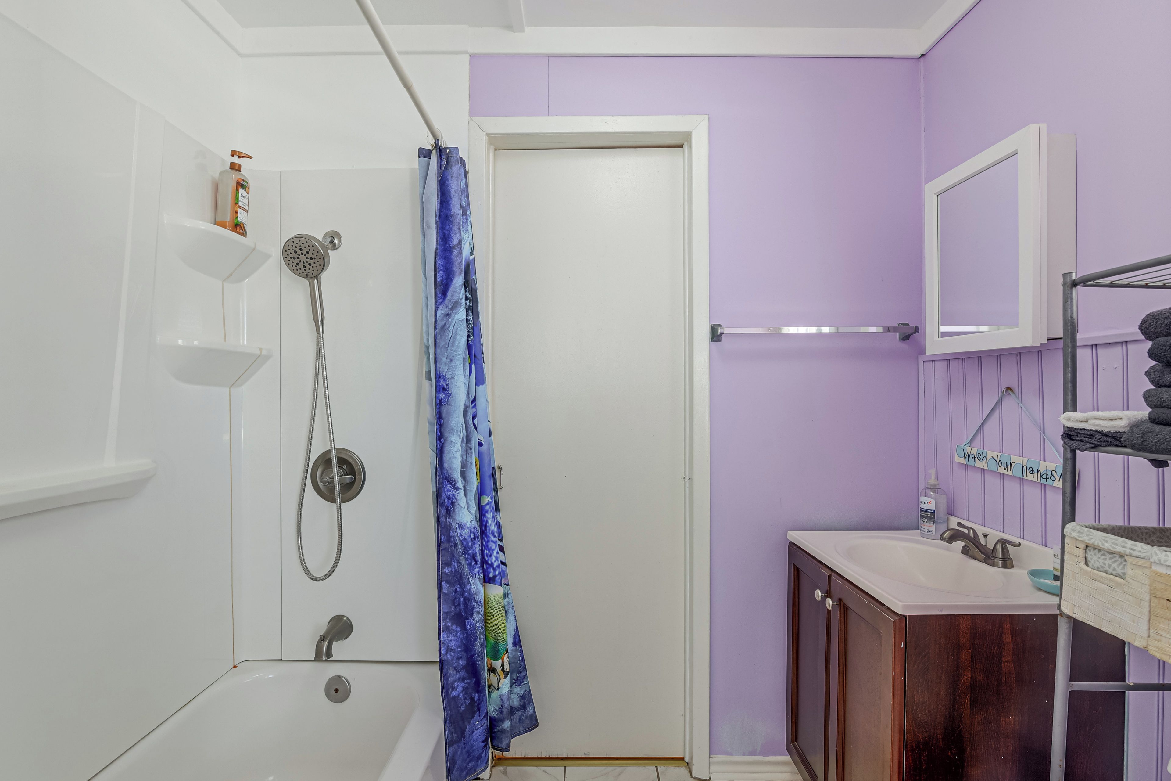 Un baño con ducha, lavamanos y espejo.