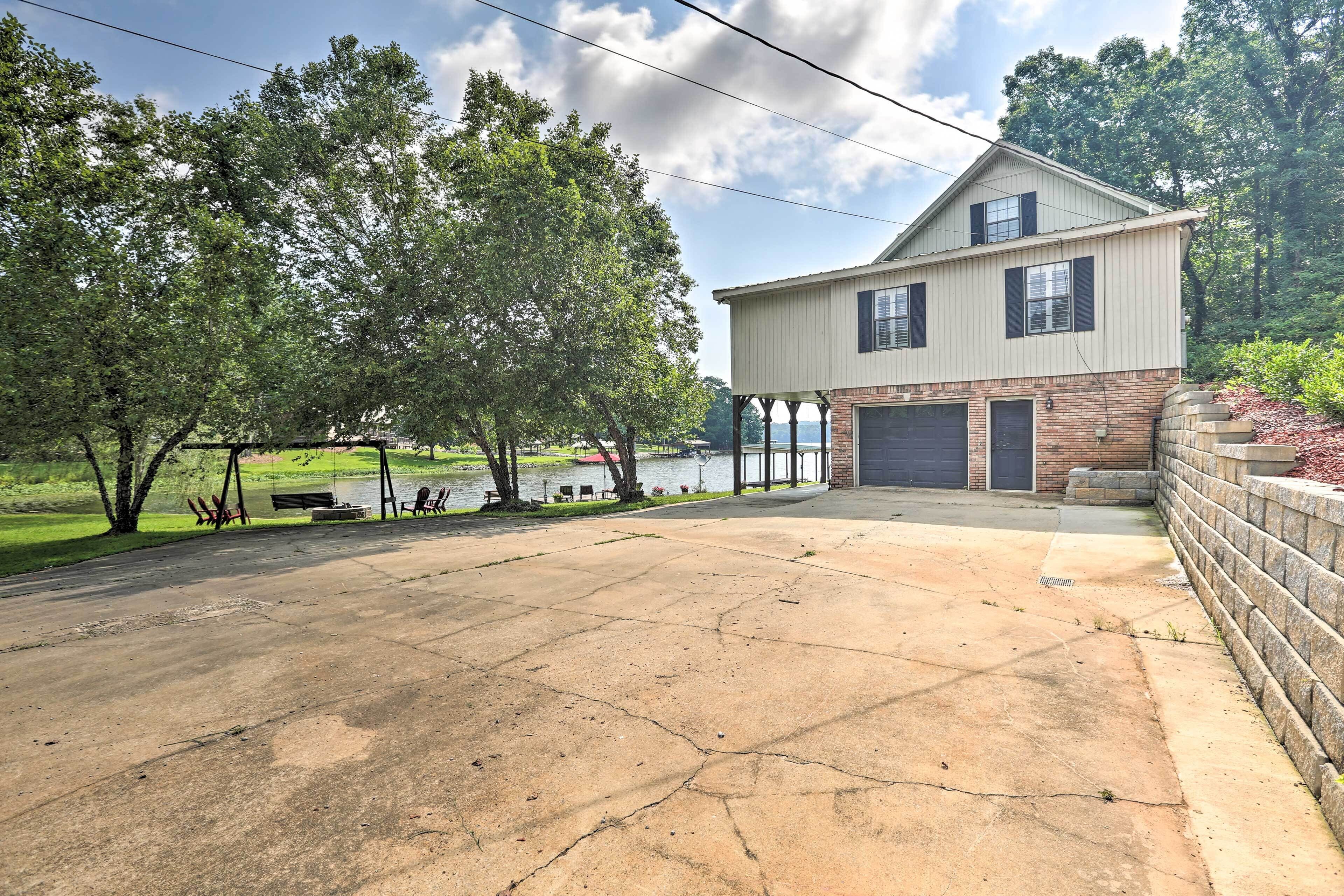 A two-story house with a garage, a covered porch, and a view of a lake.