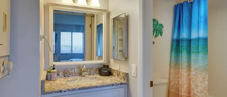 A bathroom with a sink, mirror, and toilet.