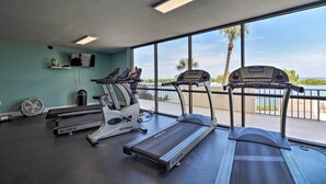 A gym with treadmills, an elliptical, and a fan. - Cozy Condo w/ Gulf View, Bird Watching + Telescope (Hudson)