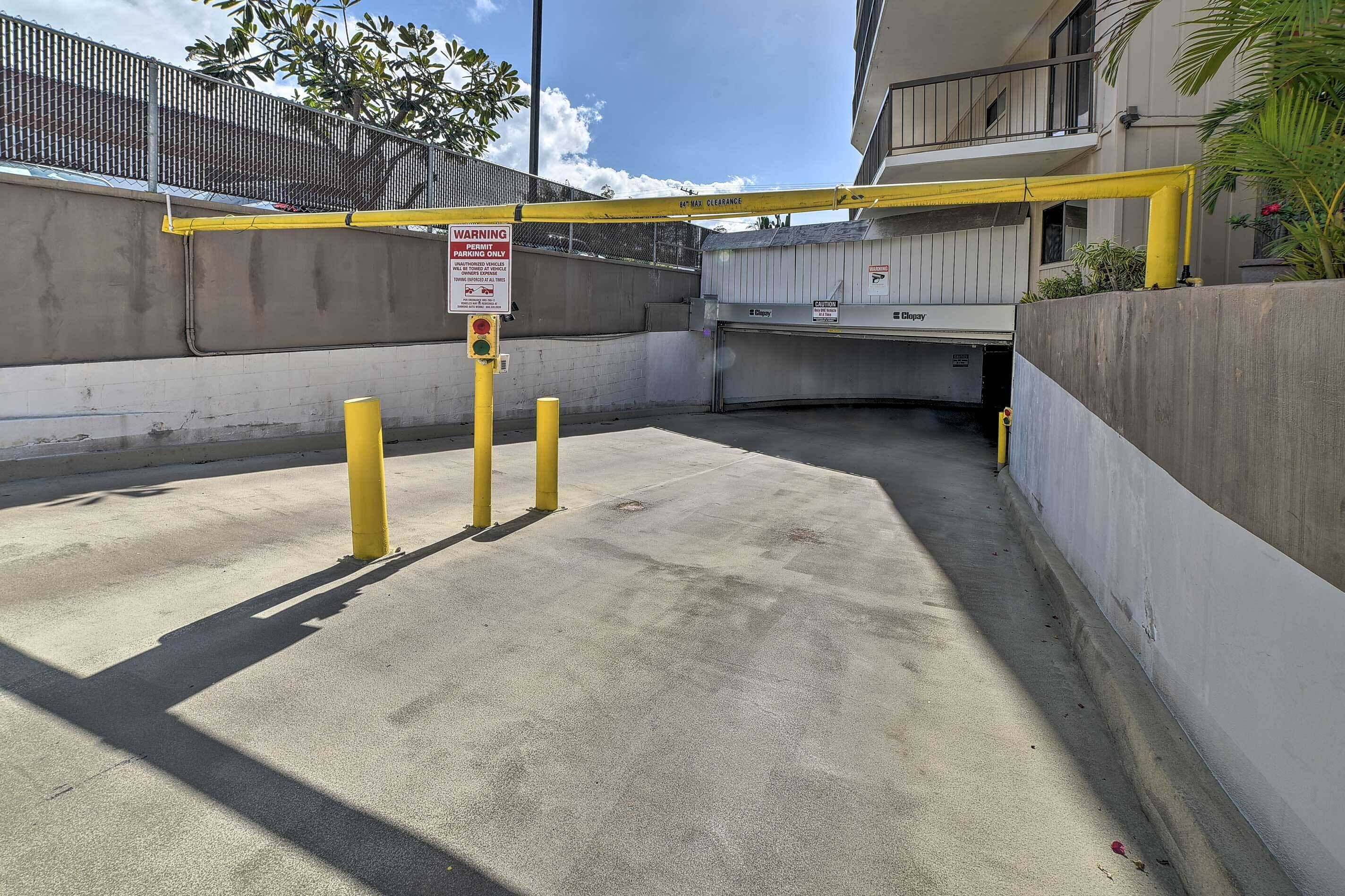 A gated parking area with a yellow barrier and a warning sign indicating parking restrictions.