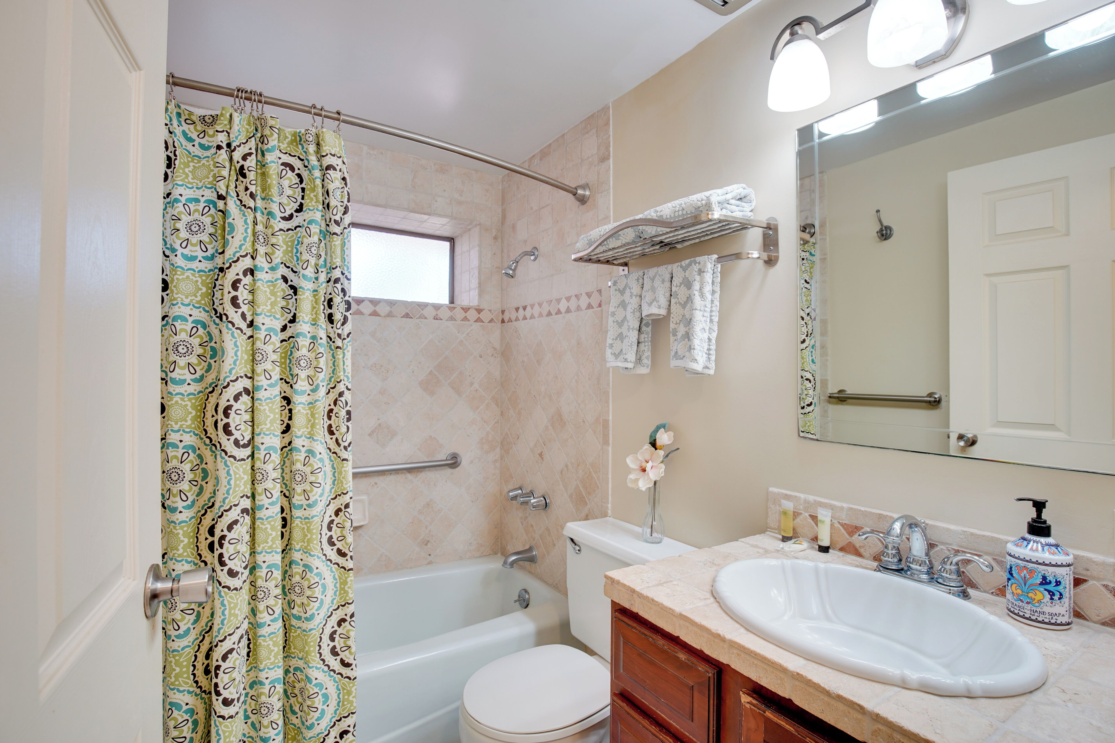 A bathroom with a bathtub, toilet, sink, and a shower curtain.