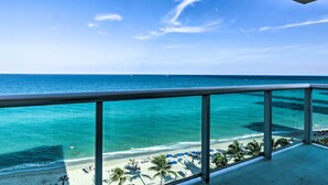 Un balcon avec vue sur une plage et l’océan.