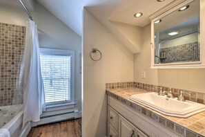 Bathroom features a large sink, mirror, and towel rack.