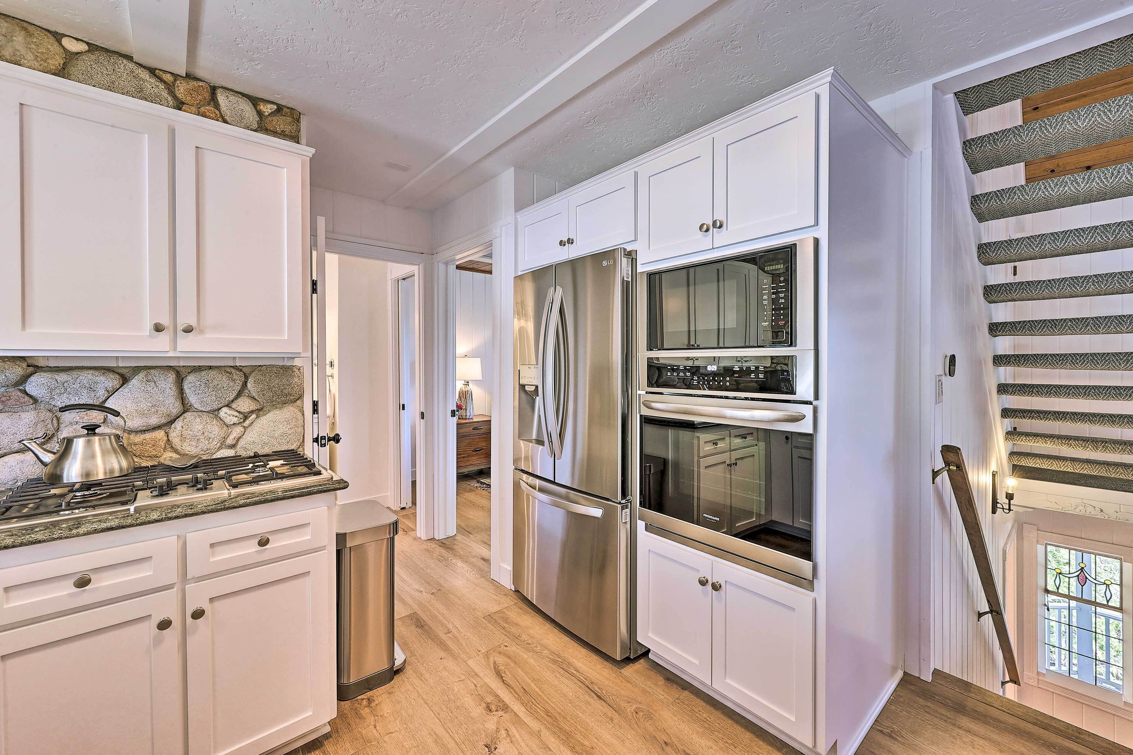 A kitchen with white cabinets, a stainless steel refrigerator, and a built-in oven.