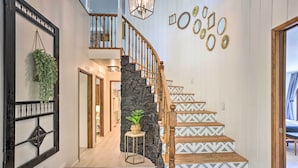 Eine Treppe mit gemusterten Stufen, eine Steinsäule und eine hängende Pflanze.