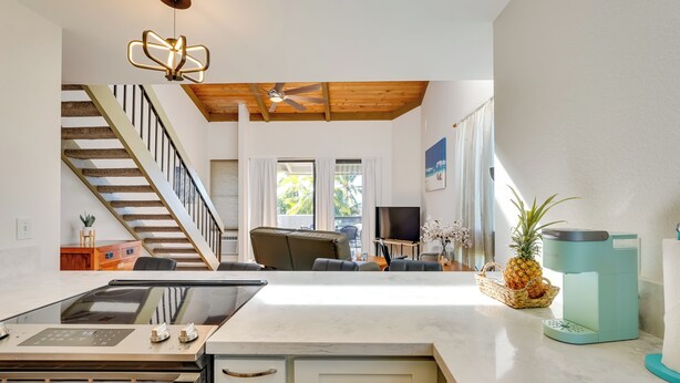 A modern kitchen with a central island, a built-in stove, and a coffee maker. - Top-floor Kailua Bay Resort Condo w/ Ocean Views! (Kailua-Kona)