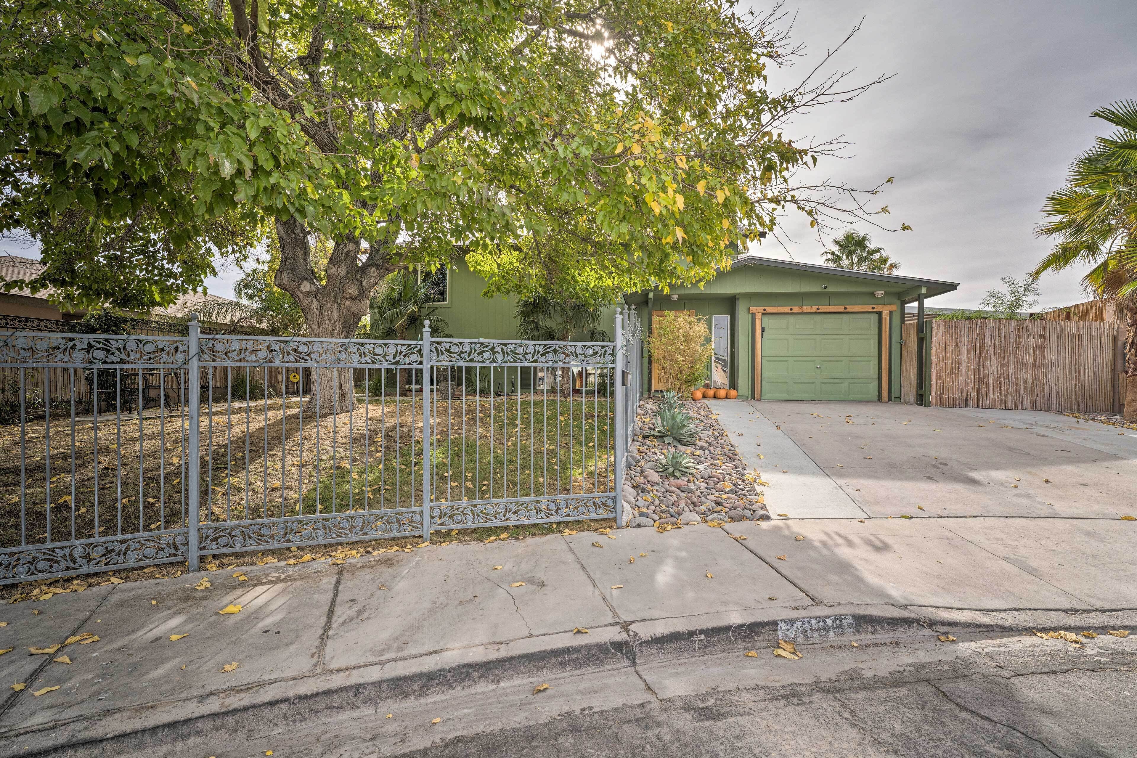 A residential property with a fenced yard, a covered garage, and a paved driveway.