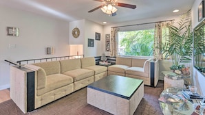 A living room with a beige sofa, a glass coffee table, and a ceiling fan. - 'vegas Oasis' Home w/ Pool & Spa: 7 Miles to Strip (Las Vegas)