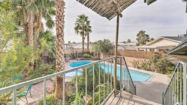A backyard with a swimming pool, palm trees, and a wooden deck. - 'vegas Oasis' Home w/ Pool & Spa: 7 Miles to Strip (Las Vegas)