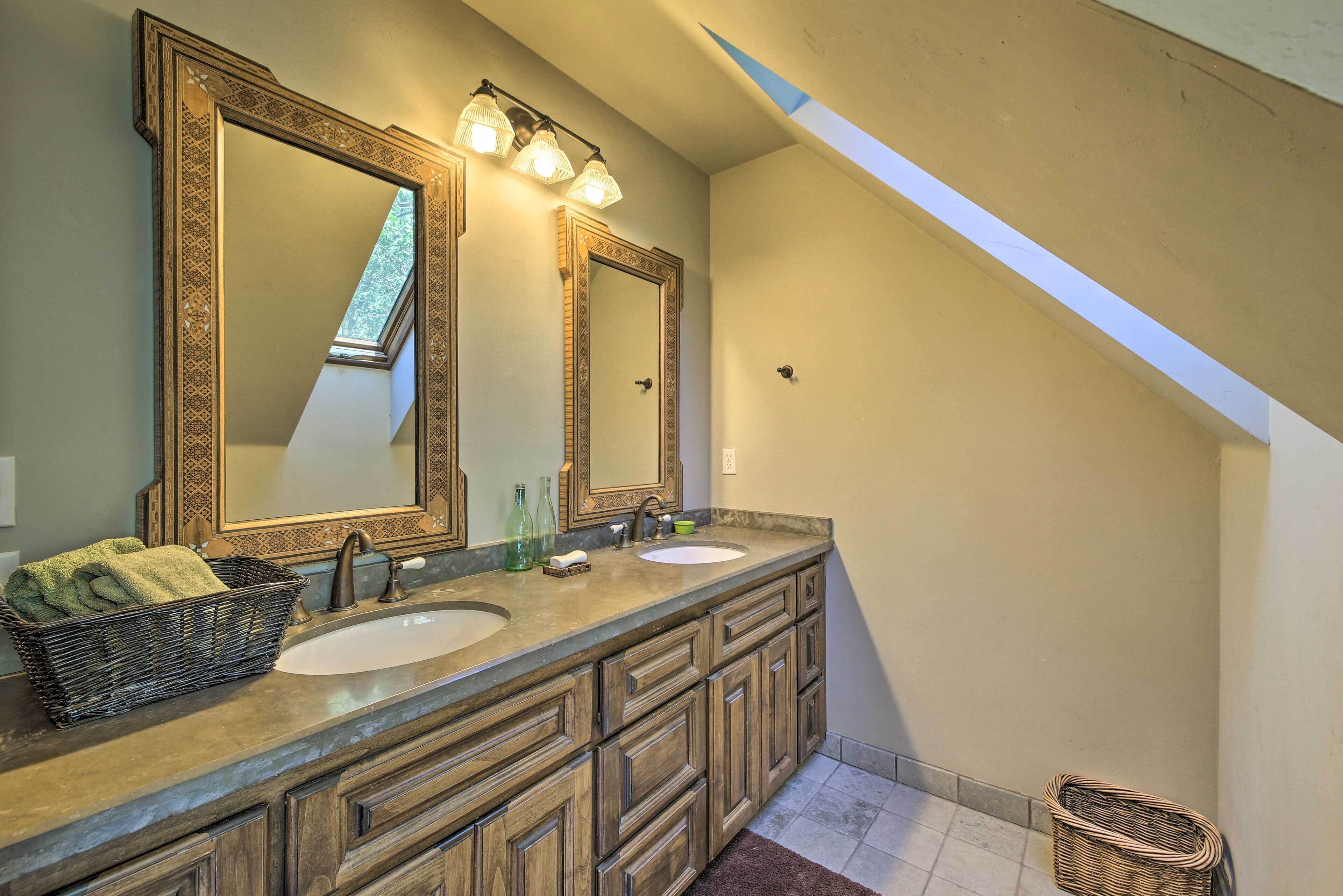 A bathroom with two sinks, large mirrors, and a wooden vanity.