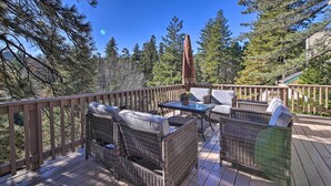 Eine Terrasse mit Korbmöbeln und einem Tisch, umgeben von Bäumen.