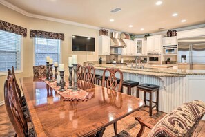 A spacious kitchen with a large island, wooden dining table, and modern appliances. - Huge Lake Arrowhead Home w/ 3 Decks & Grill! (Lake Arrowhead)