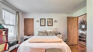 Una camera da letto con un letto grande, una libreria, una scrivania e una porta che dà su un'altra stanza.