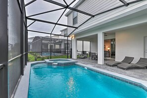 A swimming pool with a hot tub, lounge chairs, and a covered patio area. - 3 Mi to Disney: Family-friendly Home w/ Pool (Kissimmee)