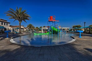 A water park with a central pool, a green slide, and blue play structures. - 3 Mi to Disney: Family-friendly Home w/ Pool (Kissimmee)
