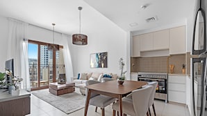Eine moderne Wohnung mit Essbereich, Küche und einem Balkon mit Blick auf die Stadt.