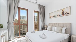 Ein modernes Schlafzimmer mit einem großen Bett, einem Stadtbildgemälde und Blick auf hohe Gebäude.