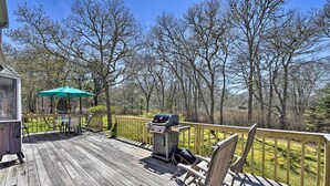 A wooden deck with a grill, chairs, and an umbrella. - Peaceful Chilmark Farmhouse by Menemsha Beach (Chilmark)
