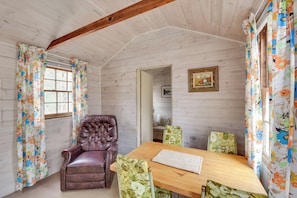 A wooden-paneled room with a wooden table and four floral-patterned chairs. - Cozy Vineyard Haven Cottage < 1 Mi to Beach! (Vineyard Haven)