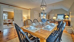 A dining area with a wooden table set for six, surrounded by black chairs. - 1 Mi to Nauset Beach: Upscale Orleans Home w/ Deck (Orleans)
