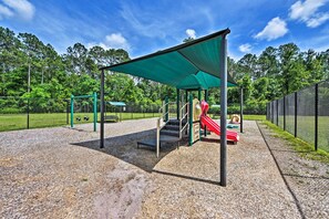 A playground with a covered play area, a slide, and a climbing structure. - Jax Home w/ Yard - 10 Mi to Adventure Landing! (Jacksonville)