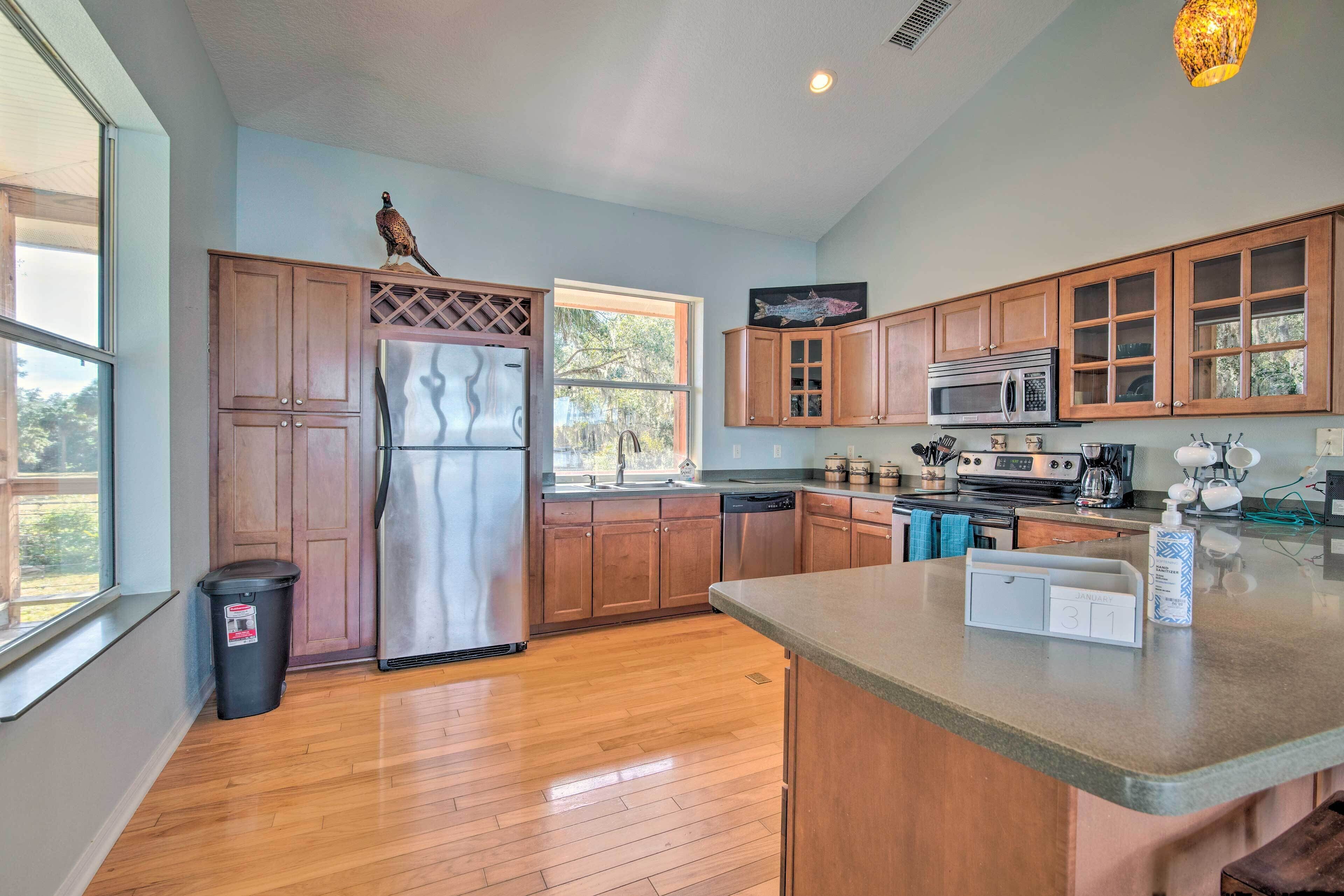 A kitchen with wooden cabinets, stainless steel appliances, and a large window.
