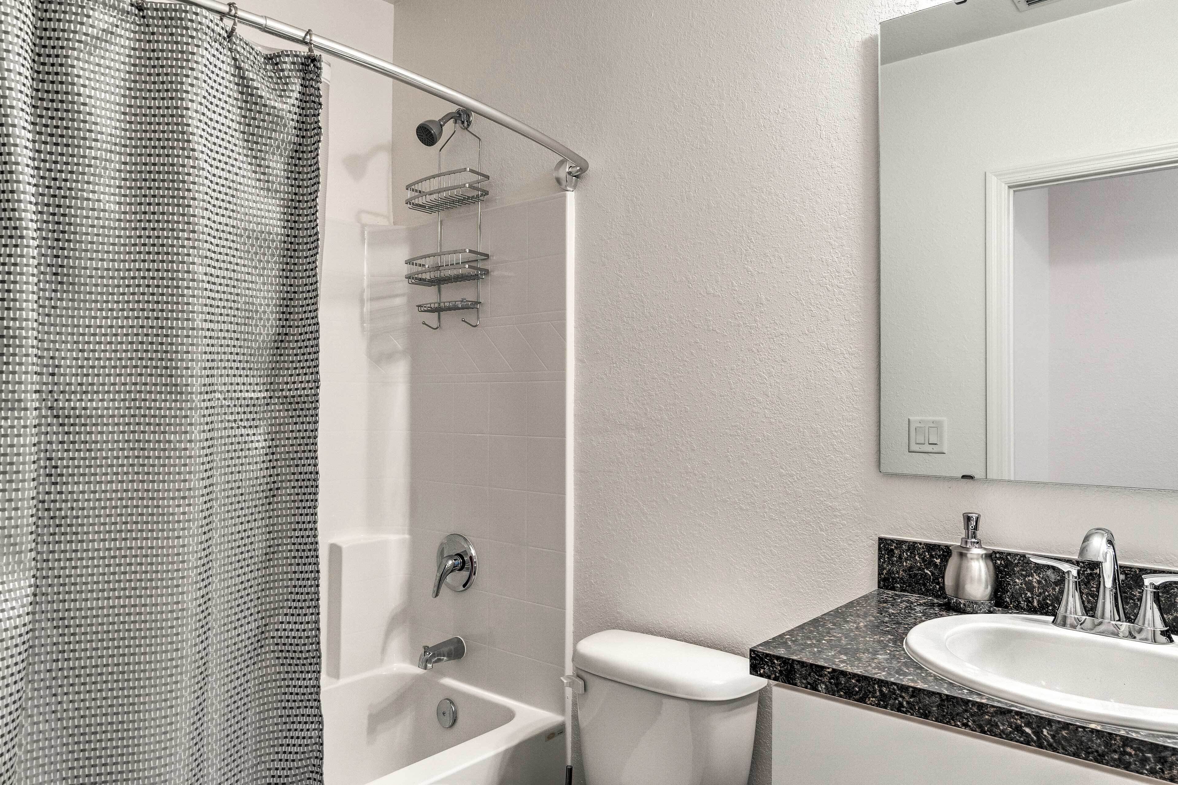 A bathroom with a shower, toilet, and sink.