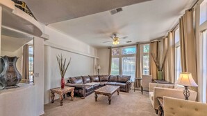 A living room with a brown leather sofa, a wooden coffee table, a beige armchair, and a floor lamp.