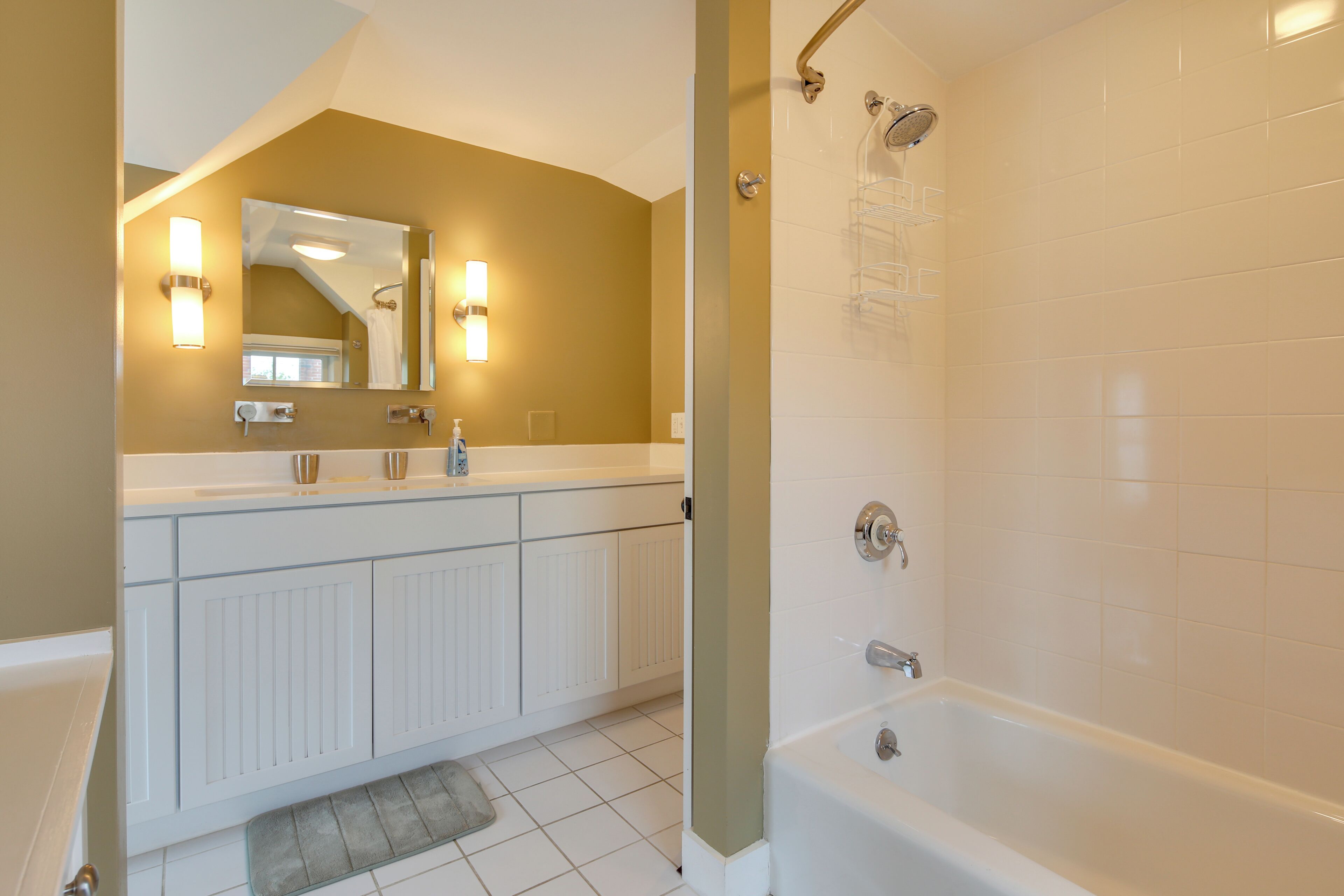 A modern bathroom with a bathtub, a vanity with a mirror, and a shower area.