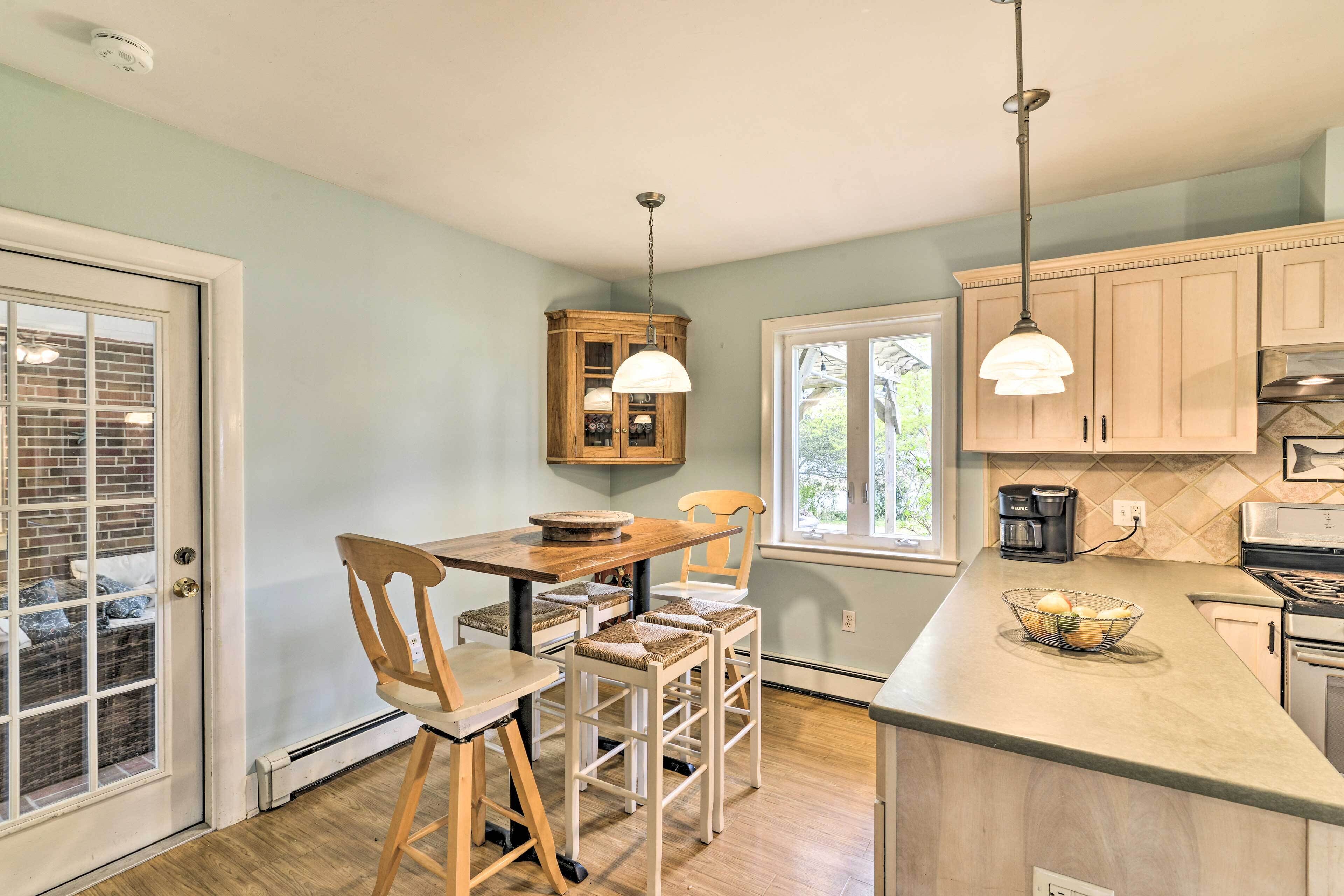 A kitchen with wooden chairs, a dining table, and pendant lights.