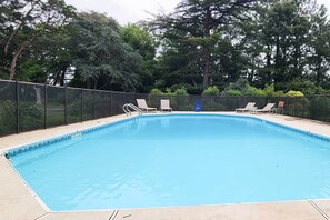 A rectangular swimming pool with a clear blue water surface, surrounded by a metal fence. - Bayfront Retreat w/ Game Room + Outdoor Pool! (Exmore)