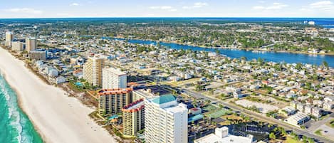 Un paisaje urbano costero con playa, edificios altos y un río.