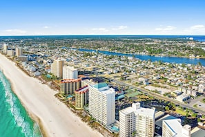 A coastal cityscape with a beach, high-rise buildings, and a river. - Walk to Beach! The Sage PCB Family Getaway (Panama City Beach)