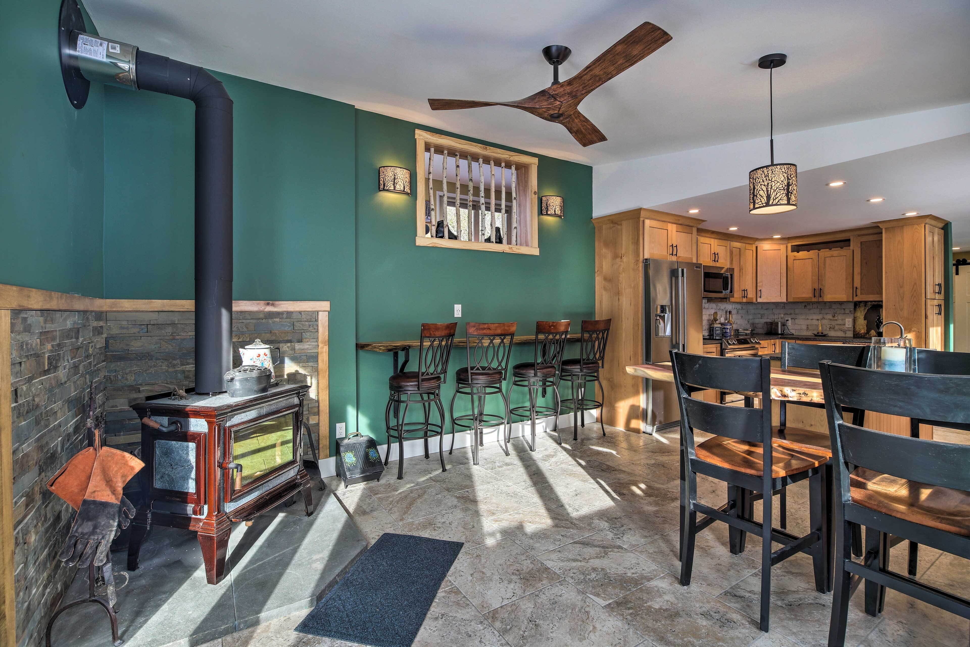 A modern kitchen with wooden cabinets, a central island, and a ceiling fan.