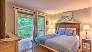 A bedroom with a large bed, two bedside tables with lamps, a wooden dresser, and a window with curtains. - Cozy Home w/ Sauna: Mins to Stowe Mountain Resort (Stowe)