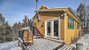 A wooden cabin with a front porch, a chimney, and a door with glass panels. - Cozy Home w/ Sauna: Mins to Stowe Mountain Resort (Stowe)