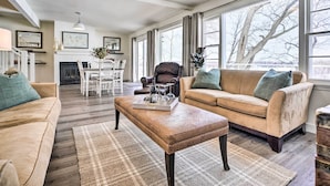 Ein geräumiges Wohnzimmer mit einem beigefarbenen Sofa, einem Holztisch und einem Kamin.